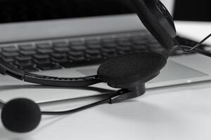 call center support concept. headset on keyboard computer laptop photo