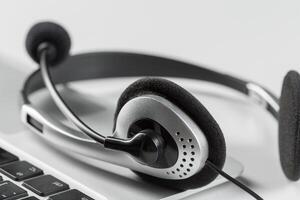 call center support concept. headset on keyboard computer laptop photo