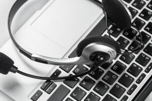 call center support concept. headset on keyboard computer laptop photo
