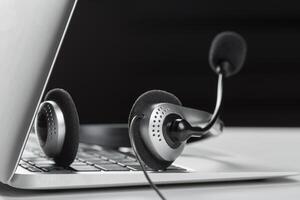 call center support concept. headset on keyboard computer laptop photo