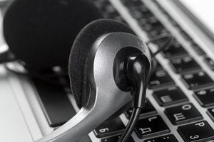 call center support concept. headset on keyboard computer laptop photo