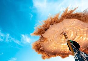 View from below of beautiful thatched umbrellas on the beach. photo