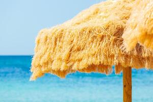 Beach beautiful thatched umbrellas and turquoise sea. photo