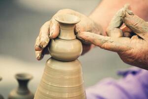 Hands making pottery on a wheel photo