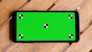 Top view smart phone place on table wood with green screen and markers. photo