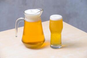 Beer in a glass draft beer pitcher on the wooden table. photo