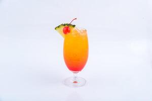 Tequila sunrise glass garnished with cherry and pine apple on the white background. photo