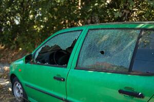 Broken glass on the passenger door of a passenger car parked. The concept of crime of car theft, theft of valuables photo