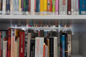Bookshelf close-up. Lots of books. There are many books on the shelves in the library. The view through the books. photo