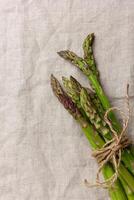 Green asparagus on a linen tablecloth with copy space photo