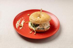 Bagel burger on a red plate. A trendy dish photo