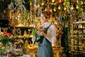 A woman in her florist shop collects bouquets of flowers. The concept of a small business. Bouquets of tulips for the holiday on March 8. photo