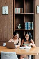 Two multiracial students in a modern office or library discuss ideas for completing an assignment, sharing thoughts and inspiration. The pleasant environment enhances their productive collaboration photo