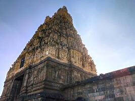 A majestic view of Belur Chennakeshava Temple in Karnataka. The intricate carvings on the towering gopuram create a visual spectacle, with light and shadow highlighting its fine craftsmanship. photo