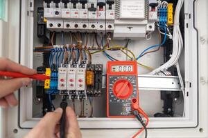 Technician Testing Electrical Circuit Board with Multimeter photo