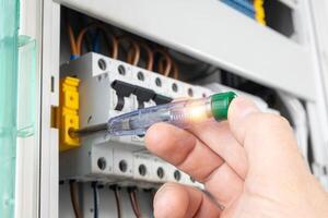 Hand Testing Circuit Breaker with Voltage Tester photo