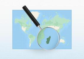 Map of the World with a magnifying glass aimed at Madagascar, searching Madagascar with loupe. vector