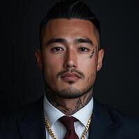 Confident man in formal attire with tattoos poses against dark backdrop photo