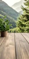 Green plant on wooden table overlooking serene mountainous landscape photo