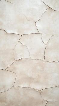 Cracked beige wall texture with irregular patterns in natural light photo
