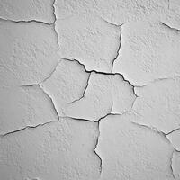 Cracked white wall texture revealing age and decay in close-up view photo