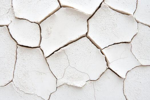 Cracked white wall surface with irregular patterns revealing wear and age photo