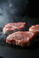 Juicy beef steaks sizzling on a hot grill in a smoky kitchen setting photo