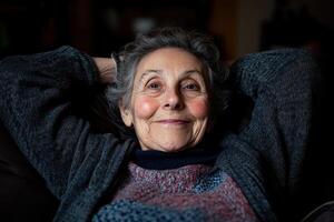 Smiling elderly woman relaxing at home in cozy sweater during evening photo