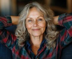Smiling woman with gray hair relaxing indoors in cozy flannel photo