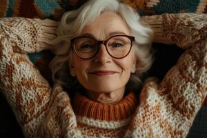 Older woman relaxing at home with a cozy sweater and joyful smile photo