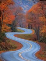 Winding road through colorful autumn trees in a mountainous area photo