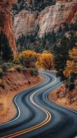Curvy road winding through autumn-colored landscape near canyons photo