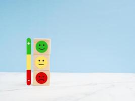 Customer experience, satisfaction, feedback, and services rating concept. Wooden cubes with sad and happy mood icons photo