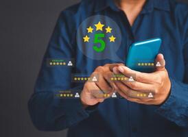Man using a smartphone give the five-star icon a rating of very impressed for service photo