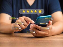 Man using a smartphone give the five-star icon a rating of very impressed for service photo