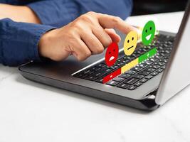 Positive feedback concept. Choosing a green happy mood icon rating review in the survey, poll, or customer satisfaction research on a virtual screen photo