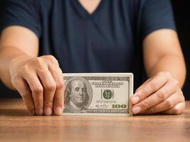 Man in casual holding US banknotes while standing in the office photo