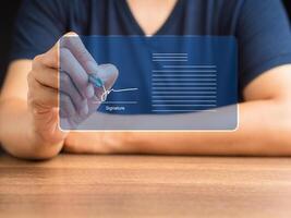 Man in casual using a pen signing electronic documents on digital documents on a virtual screen photo