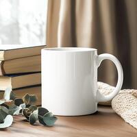 A mug and books on a table with a window photo