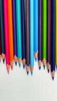 Colorful pencils arranged in a row on a white background photo