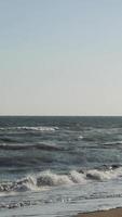Stunning sunset casts a warm glow over the ocean, illuminating the crashing waves as they meet the sandy shore. The tranquil scene evokes a sense of peace and relaxation video
