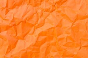 Top view and full frame of wrinkled or crumpled orange paper used as crumpled orange paper background texture. photo