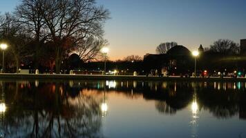 The peaceful city night view with the lights on and the reflections in water photo