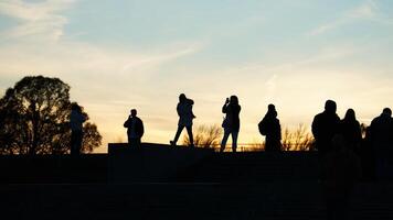The beautiful sunset view with the silhouettes of the people photo