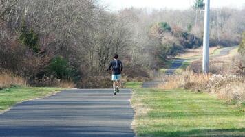 The forest view with a road cross them and several exercise people on the road photo