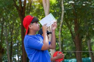 Group of boys using clinometer Measure the height of trees to calculate the trees' carbon storage.Soft and selective focus.. photo