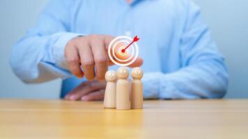 Business achievement goal and objective target, Team growing business success concept, Teamwork, Successful team, Hand holding dartboards target and human icon with line connection on wooden block. photo