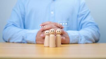 Wooden doll figure with communication and technology symbols, Social media and technology concept, Conversation exchange of ideas in an organization or in society, Joining a group listening. photo