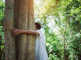 Human hands are hugging a tree in love. Representing helping to preserve the environment. Concept of saving the world. photo