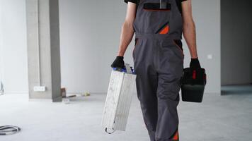 Builder in uniform walking with tools on construction site video